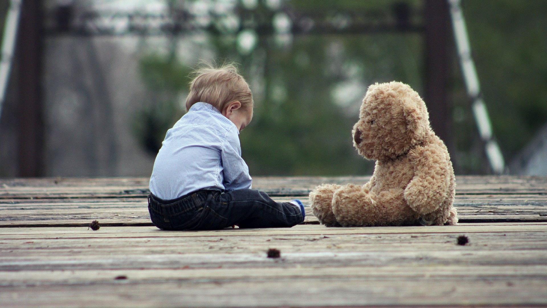 Stimmungsbild zum Beitrag: Es wird ein Kleinkind mit einem Teddybär abgebildet.