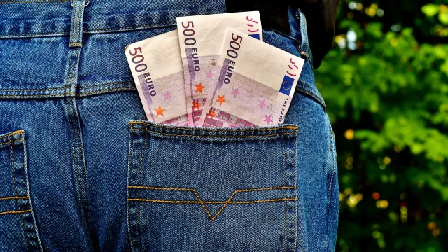Stimmungsbild zum Beitrag: Geldscheine stecken in der hinteren Hosentasche einer Jeans.
