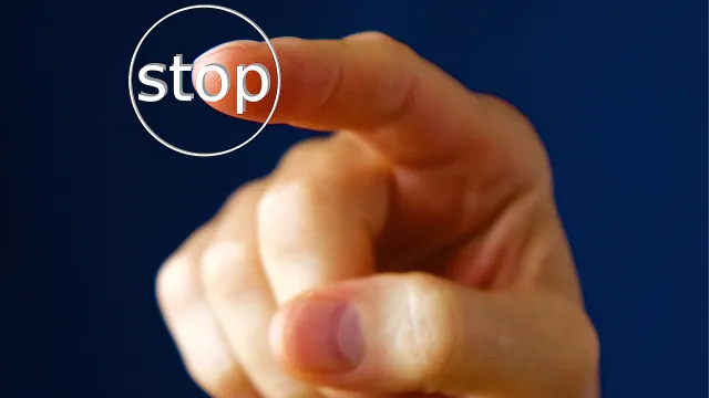 Stimmungsbild zum Beitrag: Ein Zeigefinger drückt auf einen Stop-Knopf.