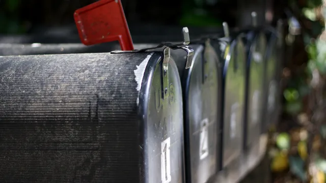 Stimmungsbild zum Beitrag: Es wird ein Briefkasten mit einer roten Fahne abgebildet.