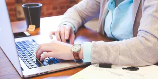 Stimmungsbild zum elektronischen Kontakt: Es wird eine Person mit einem Laptop abgebildet.