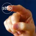 Stimmungsbild zum Beitrag: Ein Zeigefinger drückt auf einen Stop-Knopf.