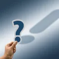 Stimmungsbild zu den FAQs: Ein Fragezeichen wirft als Schatten ein Ausrufezeichen.
