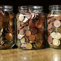 Stimmungsbild zum Beitrag: Es werden drei große Glasbehälter mit Münzen abgebildet.
