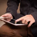 Stimmungsbild zum Beitrag: Es wird ein Mann mit einem Tablet in der Hand abgebildet.