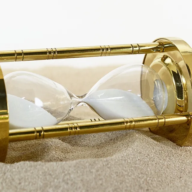 Stimmungsbild zum Beitrag: Es wird eine umgekippte Sanduhr im Sand abgebildet.