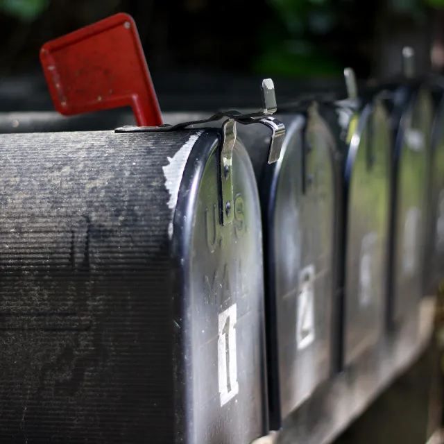 Stimmungsbild zum Beitrag: Es wird ein Briefkasten mit einer roten Fahne abgebildet.