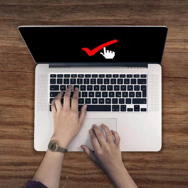Stimmungsbild zum Beitrag: Es wird ein Laptop mit einem roten Haken auf dem Bildschirm abgebildet.