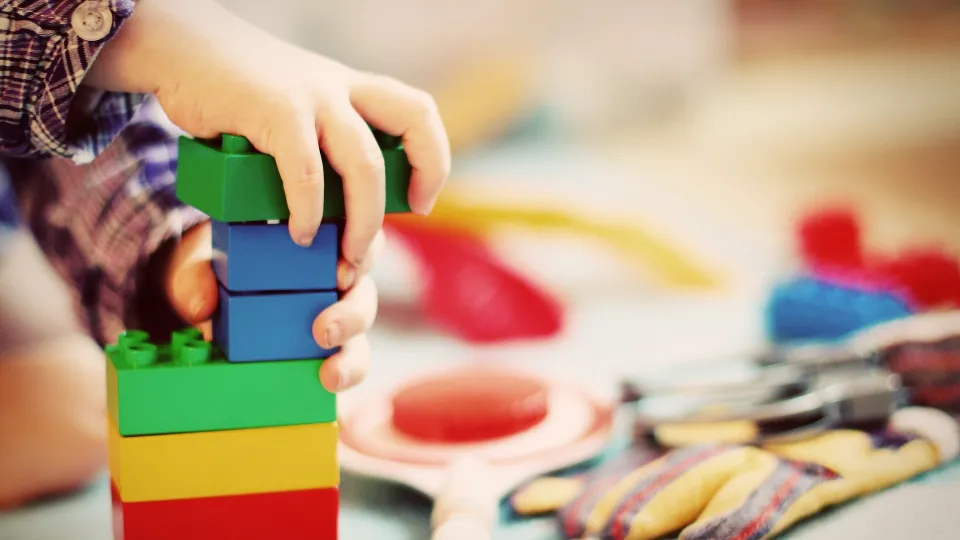 Stimmungsbild zum Beitrag: Ein Kind spielt mit bunten Duplo-Steinen.