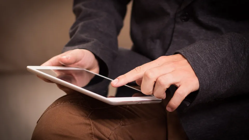 Stimmungsbild zum Beitrag: Es wird ein Mann mit Tablet in der Hand abgebildet.