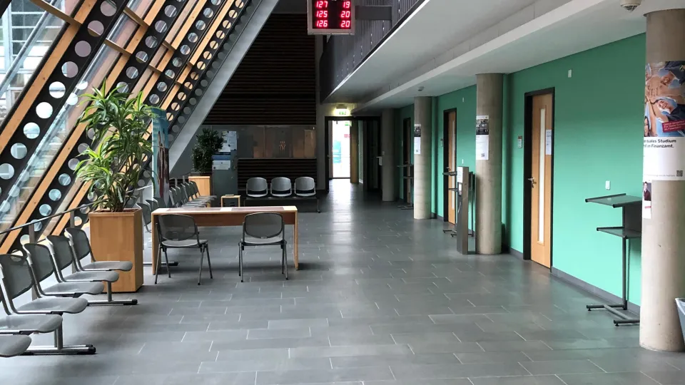 Stimmungsbild zum Beitrag: Es wird ein Foyer mit Stühlen und einer Warteanzeige abgebildet.