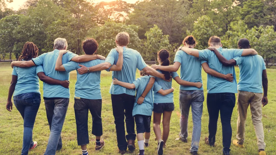 Stimmungsbild zum Beitrag: Es werden neun Personen, die Arm in Arm weggehen, abgebildet.